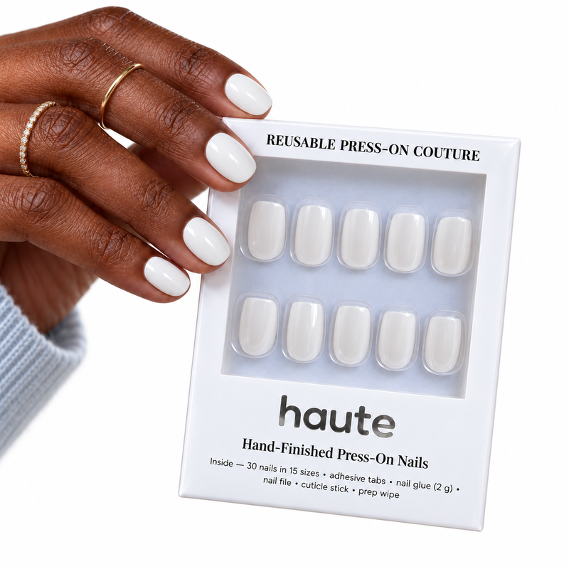 milk money short square milky white press-on nails worn while holding the haute box